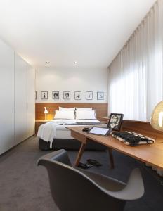 een slaapkamer met een bed en een bureau met een stoel bij Maison Wyck in Maastricht