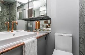 bagno con lavandino, servizi igienici e specchio di Unique Studio House | City Centre a Lisbona