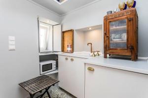 una cucina con armadietti bianchi e forno a microonde di Unique Studio House | City Centre a Lisbona