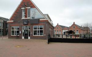 un edificio de ladrillo con una gran ventana en la parte superior en Hotel Aan De Singel, en Delfzijl