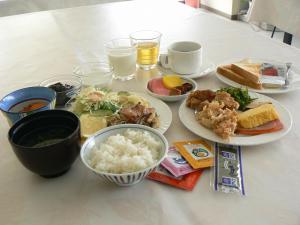 una mesa con platos de comida y cuencos de arroz en Smile Hotel Towada, en Towada