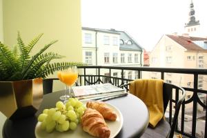 a table with a plate of bread and a glass of orange juice at Tallinn City Apartments Old Town Suites in Tallinn