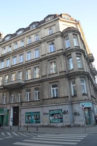 un grand bâtiment en pierre au coin d'une rue dans l'établissement Ada Aparthouse, à Wrocław