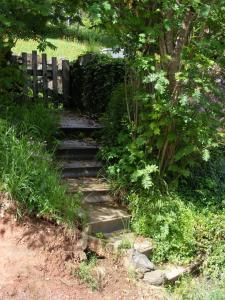 um conjunto de escadas num jardim com uma cerca de madeira em Ferme Hurlet em Stavelot