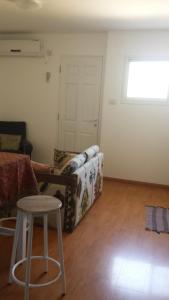 sala de estar con sofá y taburete en Alona, en Kefar Weradim