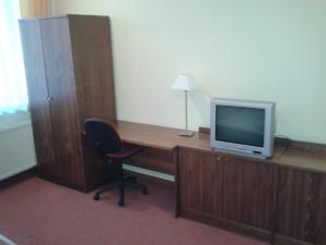 een kamer met een bureau, een televisie en een stoel bij Parkhotel Centrum in Spišská Nová Ves