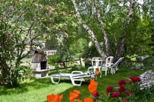 a yard with a picnic table and chairs and flowers at Studio in Chasa Quirin in Zernez