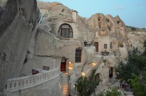 a building in a mountain with stairs in it at Cappadocia Gamirasu Cave Hotel in Urgup