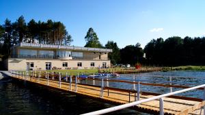 a large building with a dock next to a body of water at Kaszubówka 22 in Załakowo