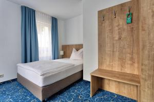 una camera con letto e parete in legno di Appartis - Hotel am Stadtpark a Sindelfingen