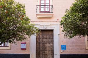 een gebouw met een houten deur en een balkon bij Hotel Casa de las Cuatro Torres in Cádiz