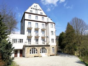 un grande edificio bianco con una torre di Rezydencja Zamek a Krynica-Zdrój