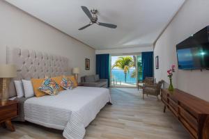 Vista Vallarta All Suites On The Beach في بوسيرياس: غرفة نوم بسرير وتلفزيون بشاشة مسطحة