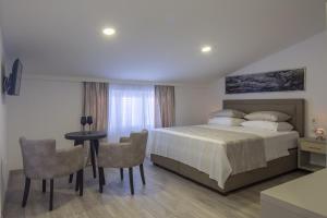 een slaapkamer met een bed en een tafel en stoelen bij Villa Mandalinic in Omiš