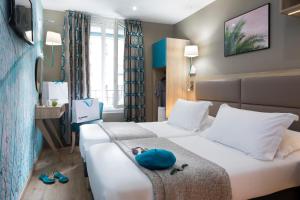 ein Hotelzimmer mit einem Bett mit Schuhen darauf in der Unterkunft Hotel Daumesnil-Vincennes in Vincennes