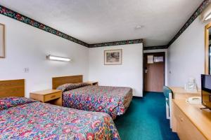 a hotel room with two beds and a television at 9 Motel in Fort Collins