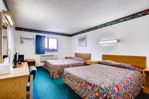 a hotel room with two beds and a desk at 9 Motel in Fort Collins