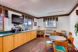 a room with a table and a tv and a dining room at 9 Motel in Fort Collins