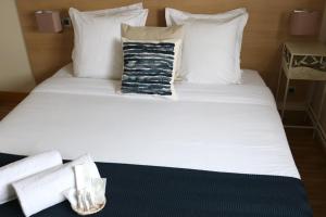 - un lit blanc avec une serviette et une bougie dans l'établissement Hotel Le Transat Bleu, à Dunkerque