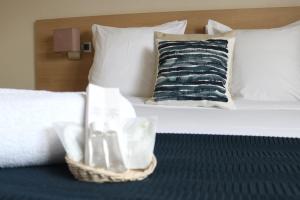 - un lit avec un panier de serviettes et un oreiller dans l'établissement Hotel Le Transat Bleu, à Dunkerque