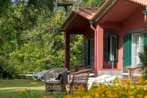 een groep stoelen en tafels buiten een huis bij Quinta Santo Antonio Da Serra in Santa Cruz