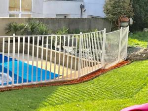 una valla blanca en un patio con piscina en Hôtel Le Cerizay, en Cerizay