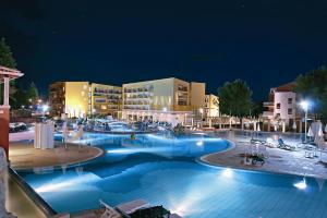 a large swimming pool in a resort at night at Hotel Garden Istra Plava Laguna in Umag