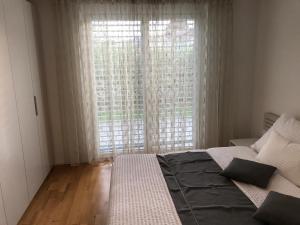 ein Schlafzimmer mit einem Bett und einem großen Fenster in der Unterkunft Skender's Apartment in Interlaken