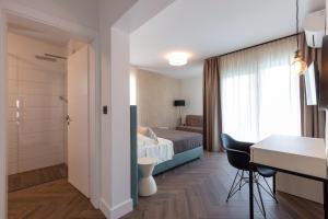 Pokój hotelowy z łóżkiem, biurkiem i stołem w obiekcie Luxury Villa Karla w Podstranie