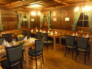 une salle à manger avec des tables et des chaises en bois dans l'établissement Gasthaus Auwirt, à Fieberbrunn