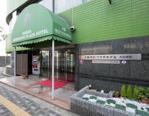 un negozio di fronte a un edificio con tenda verde di Osaka Moriguchi Plaza Hotel ad Osaka