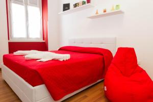 ein rot-weißes Schlafzimmer mit einem weißen Bett und einer roten Decke in der Unterkunft Residence Theresia- Tailor Made Stay in Triest