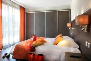 una camera da letto con un grande letto con pareti arancioni di Seventeen Hotel a Valbonne