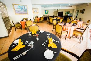 une salle à manger avec une table noire et des serviettes jaunes dans l'établissement Altamont Court Hotel, à Kingston