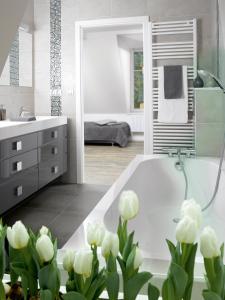 een badkamer met een wit bad en witte bloemen bij Appartements Le 32 in Straatsburg