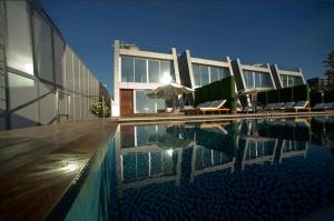 une maison avec une piscine en face d'un bâtiment dans l'établissement Veer Luxury Boutique Hotel & Beach Club, à Jounieh