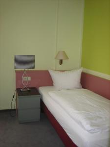 a bedroom with a bed and a lamp on a table at BSW Ferienhotel Lindenbach in Bad Ems