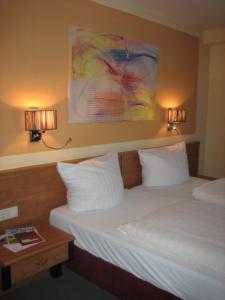 a hotel room with a bed and two lights on the wall at BSW Ferienhotel Lindenbach in Bad Ems