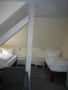 a room with two beds and a chair in it at BSW Ferienhotel Lindenbach in Bad Ems