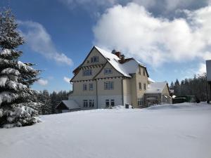 腓特烈罗达Hotel und Berggasthof Spießberghaus的一座大白房子,地面上积雪