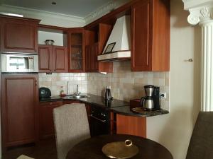 cocina con armarios de madera y mesa con cafetera en GoldStar Luxury Old Town Krakow Apartment, en Cracovia