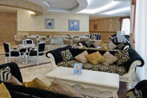 een woonkamer met een bank en tafels en stoelen bij Duni Marina Royal Palace Hotel - Ultra All Inclusive in Sozopol