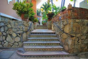 a stone wall with stairs next to a building at Hotel Santa Fe in Puerto Escondido