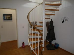 eine Wendeltreppe in einem Haus mit einer Statue in der Unterkunft Maisonette am Belchen in Bad Krozingen