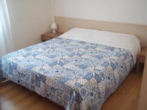 um quarto com uma cama com uma colcha azul e branca em Hotel Gronda Lagunare em Tessera