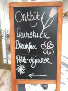 ein Tafelschild für ein Restaurant mit Blumen darauf in der Unterkunft Hotel Restaurant de Engel in Lisse