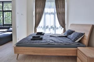 ein Bett in einem Schlafzimmer mit einem großen Fenster in der Unterkunft Loft on Owl Hill in Kaunas