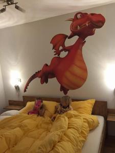 two children laying on a bed with a dragon on the wall at Ruster Drachennest in Rust