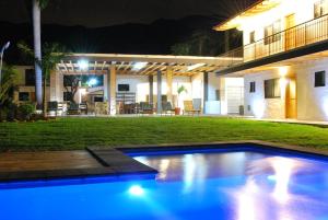 una piscina di fronte a una casa di notte di Hotel La Ribereña a Ajijic