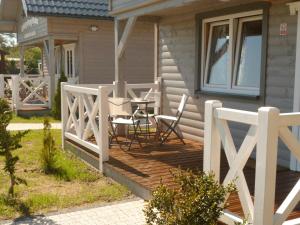 una terrazza in legno con tavolo e sedie su una casa di Cztery Pory Roku a Trzęsacz